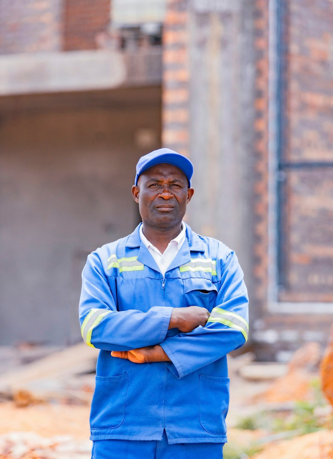 Confident FlowGuard Plumbing technician in a navy uniform on a residential job site